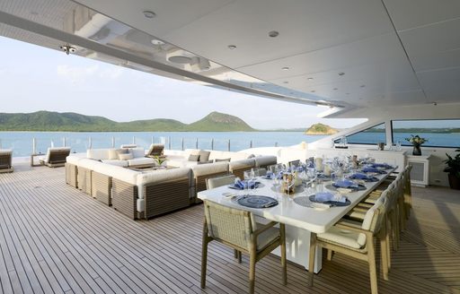 Exterior deck onboard charter yacht ARBEMA, with alfresco dining option forward and seating in the background