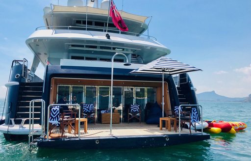 Aft view of charter yacht LADY AZUL at sea, with furniture on the swim platform and watertoys adjacent to the superyacht