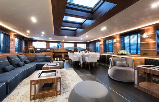 walnut woodwork and angular furniture in main salon of luxury yacht Rox Star