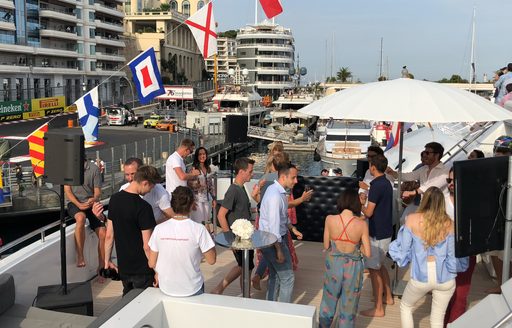 People milling at a trackside corporate event on board a yacht