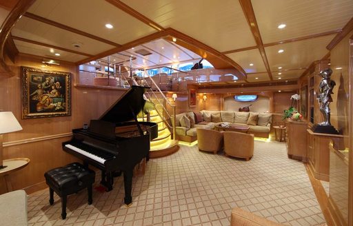 Main salon with grand piano and seating area aboard luxury sailing yacht MARIE