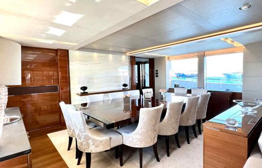 Interior dining area onboard charter yacht LE VERSEAU, with large window in the background.