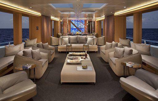 lounge in foreground and dining area beyond on board luxury yacht ‘Big Fish’ 