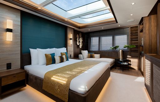 Master cabin onboard charter yacht MANA I, central berth facing starboard with three big windows in the background