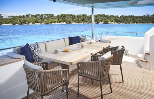 Exterior dining area onboard charter yacht ANKA, long table with wicker seats