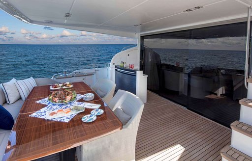 the aft deck with alfresco dining area on charter yacht hot pursuit looking out towards the bahamas