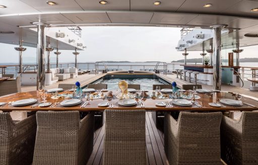 Alfresco dining setup onboard superyacht charter OCTOPUS with swimming pool aft