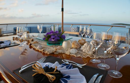 table laid for alfresco dinner on deck of motor yacht ‘Lady J’ 