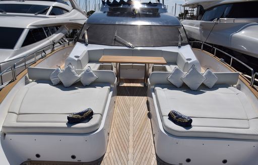 Sunpads on the foredeck of Sunseeker motor yacht, with small dining set-up