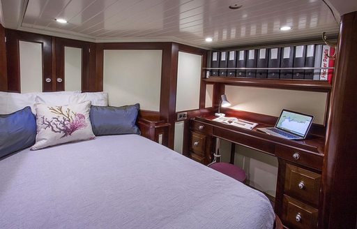Bed and desk in master suite of charter yacht Savarona