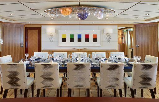 Dining table with glass light feature above on board charter yacht Victoria del Mar