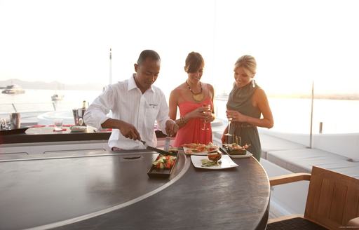 chef serves up some food to guests on teppenyaki grill on board charter yacht SPIRIT 
