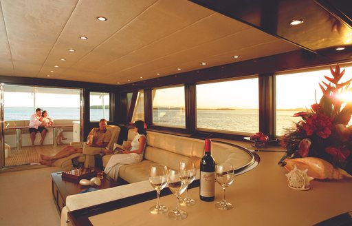 charter guests enjoy a glass of wine in skylounge of motor yacht ‘Emerald Lady’