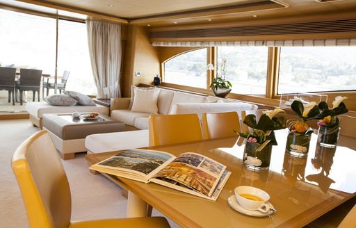 dining table with lounge beyond in main salon of charter yacht PERPETUAL
