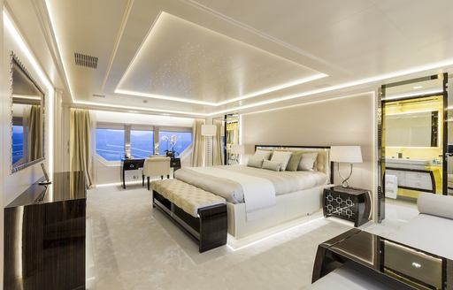 Overview of the master cabin onboard charter yacht PARILLION, central berth facing port with large window in background.