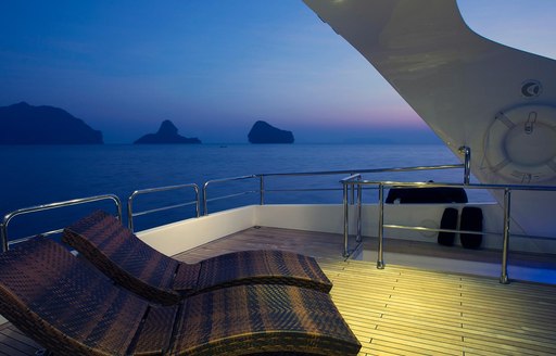 Sundeck on luxury yacht Mia Kai, with sun loungers and views over scenery 