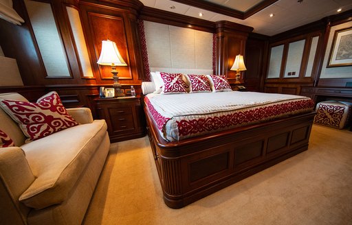 Guest cabin onboard charter yacht NOMAD, central berth facing forward with sofa in foreground