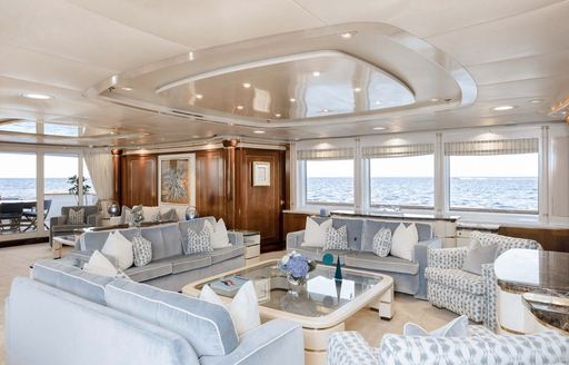 Interiors onboard super yacht charter OLYMPUS, spacious lounge surrounded by windows