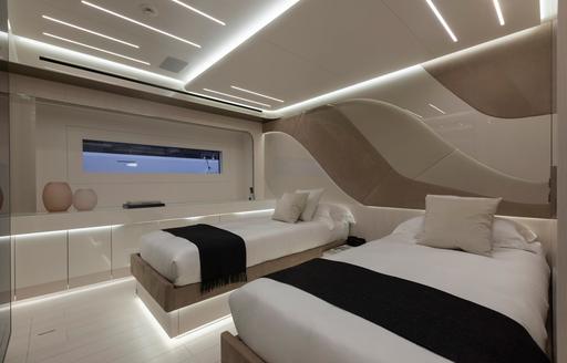 Twin guest cabin onboard charter yacht N1, two single berths on either side of cabin with a narrow hull window adjacent