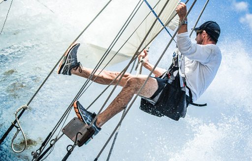 Man climbs rigs of classic yacht during Antigua Classic Yacht Charter