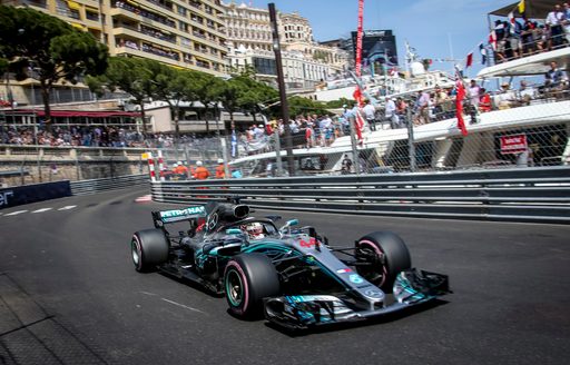 A car races by yachts at the Monaco Grand Prix