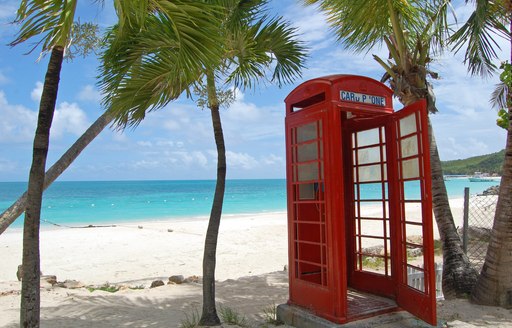 Red phone box on a tropical beach in Antigua, Cariibean