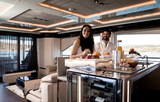 man and woman sit at breakfast bar on board motor yacht hanaa