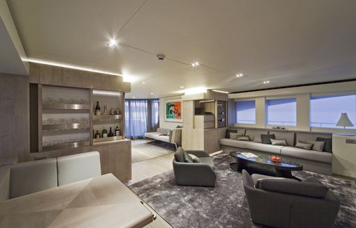 Contemporary main salon with pale woods and grey furnishings on board charter yacht JEMS