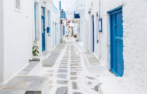 White cobbled street in Greece, with blue doors 
