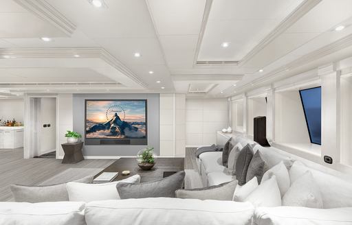 Overview of the interior lounge area onboard charter yacht ARBEMA. Corner seating under windows, facing a wall mounted TV.