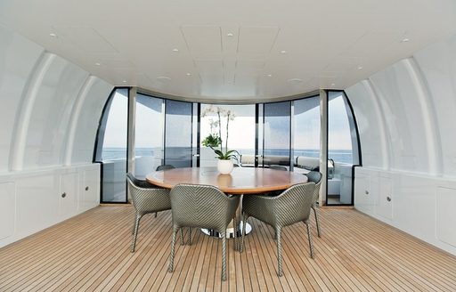 alfresco dining on sundeck with glass sliding windbreak on board superyacht OKKO 