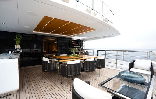 Exterior dining setup onboard private yacht charter HALARA with armchairs in the foreground