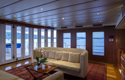 main salon with tall windows and cream sofa on superyacht northern sun