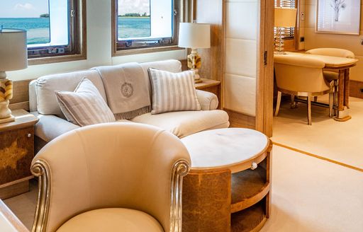 Master cabin lounge area onboard charter yacht ARTEMISEA, plush sofa and coffee table with additional seating in the background