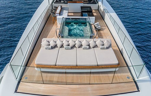 Overview of the sun deck onboard charter yacht SEVERIN'S, with sun pads bordering an on-deck Jacuzzi