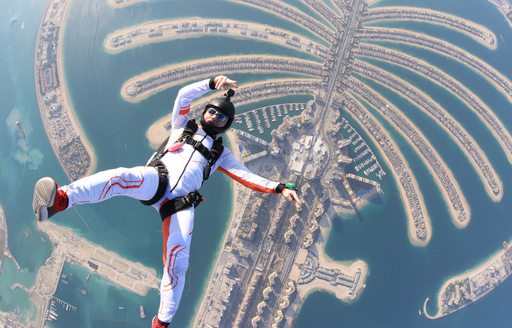 A man skydiving in Dubai over man-made palm-tree islands