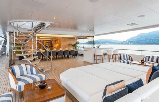 main deck aft alfresco dining and socialising on m/y joy with interior of yacht in background