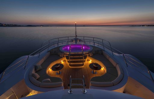 Aerial view of sundeck of luxury yacht Mine Games at sunset with Jacuzzi lit up