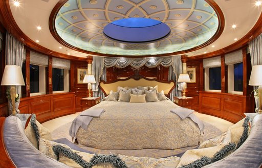 Master cabin onboard private yacht charter ST DAVID, with central berth surrounded by large windows