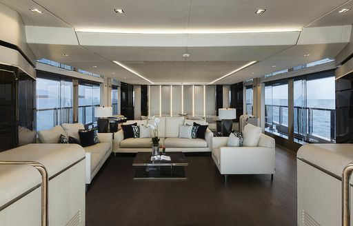 Main salon onboard boat charter SANCTUARY, with white seating surrounded by large windows