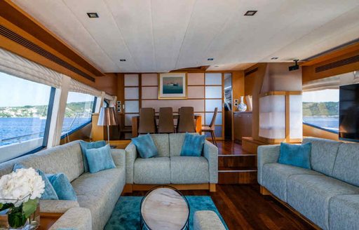 Overview of the main salon onboard charter yacht ORLANDO L, spacious lounge area forward with dining area aft