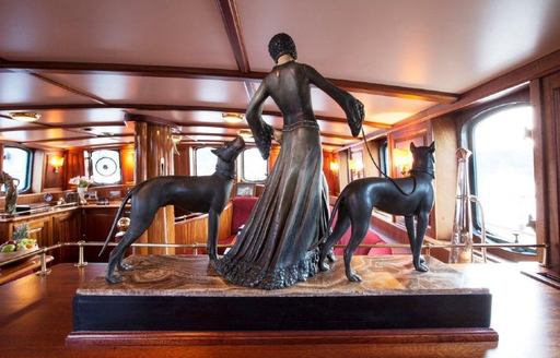 Art deco ornament of woman and two dogs in main salon of sailing yacht silver spray