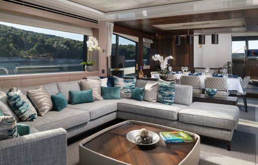 Main salon onboard charter yacht MOWANA, spacious L-shaped sofa and low coffee table