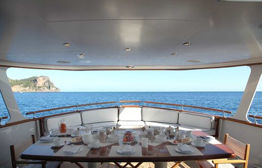 main aft deck dining area is set for breakfast aboard charter yacht ‘Heavenly Daze’ 
