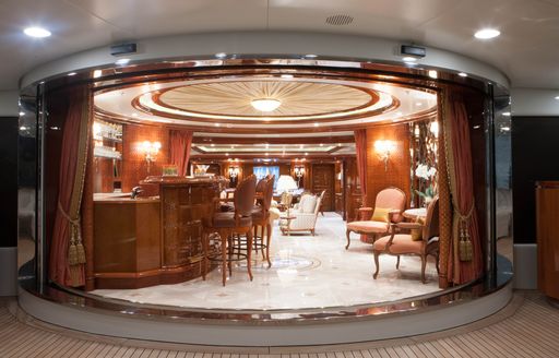 motor yacht st david dining area with polished wood and cream carpet, circular shaped