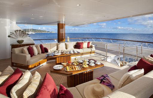 Aft main deck on charter yacht LADY BRITT, large lounge area with a coffee table and surrounding views of the sea