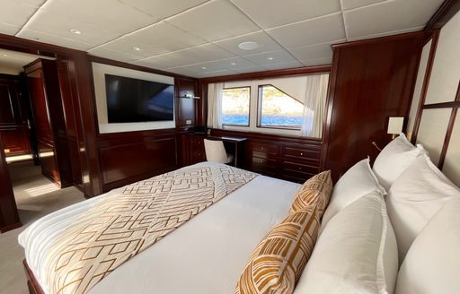 Guest cabin onboard charter yacht GENESIA, central berth facing forward with windows in the background