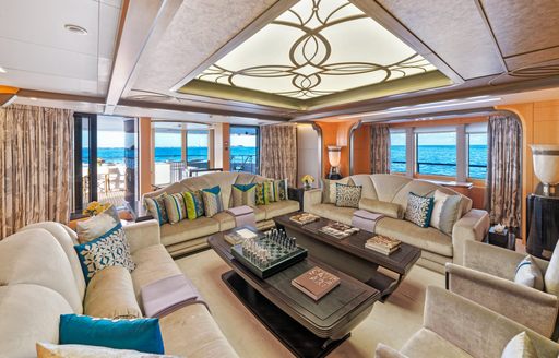 Interior lounge area onboard charter yacht AMARYLLIS, large cream sofas arranged to face inwards