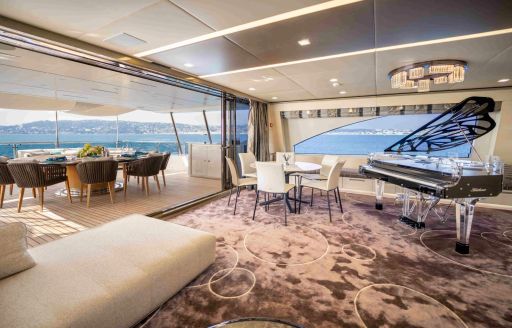 Seating area and grand piano onboard boat charter CHARADE