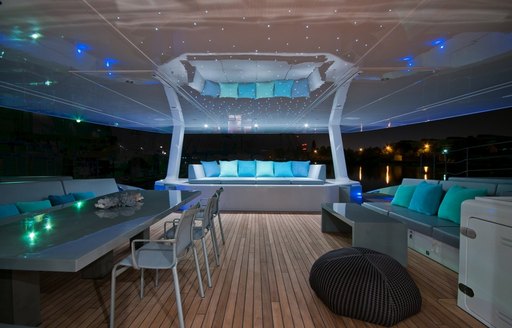 the main deck aft of charter yacht che with sumptuouse seating and an alfresco dining area